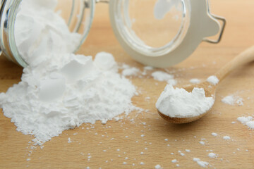 Close-up of tapioca starch or flour powder in wooden spoon with wooden background
