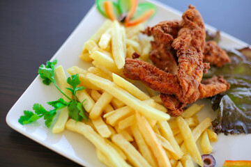 French fries and chicken pieces on a plate