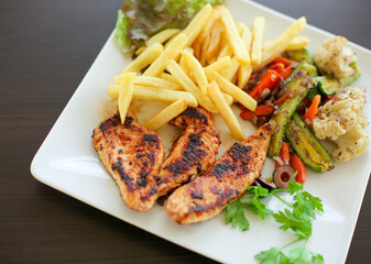 French fries and chicken pieces on a plate