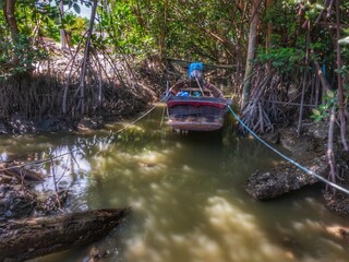 Blurred of image. Local fishing boat moored on the small canal at low tide in Samut Sakhon Province, Thailand