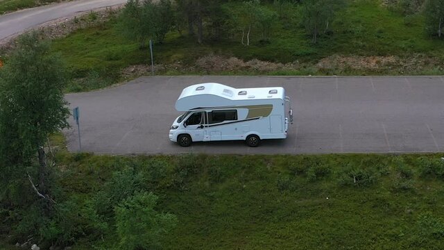 Aerial view of a RV, resting at a campsite, near Yllas, in Kolari, Lapland, Finland - pull back, drone shot