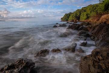 Obraz premium long exposure of sea waves lash line impact rock on the beach at morning time at Koh yao yai,Thailand