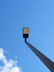 A tall street light against a blue sky