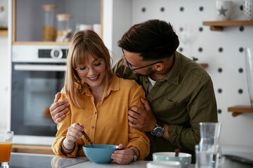 Boyfriend and girlfriend making delicious food. Loving couple eating breakfast together at home.