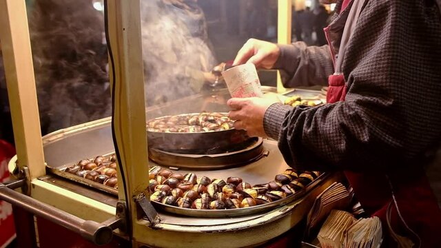 Unidentified Turkish man sells sweet chestnuts on smoke in Istanbul, Turkey.