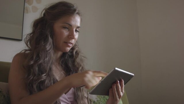 Young caucasian woman using master card and digital tablet while shopping at home. Woman shopping at home. Woman buys online.