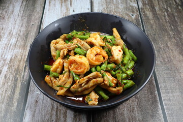 Traditional fried and stirred cutting green bean with chopped chicken thigh and fresh peeled shrimp seasoning with red chilly paste on the plate. Famous Thai hot and spicy food in Asia restaurant. 