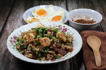 Traditional fried and stirred cooked rice with cutting green bean, fresh peeled shrimp and chopped pork sausage on the plate. Famous special breakfast in the morning in Asia.