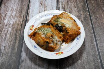 Traditional steamed fish meat with red chilly paste topping with coconut milk cream in Thai style on the plate. Famous hot and spicy appetizer menu in Asia restaurant. 