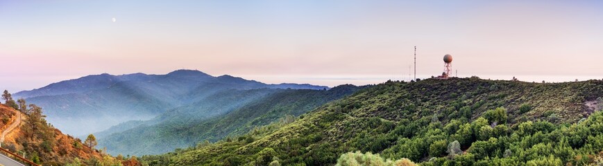 Panoramic sunset views in Santa Cruz mountains; Smoke from the nearby burning wildfires, visible in the air and covering the mountain ridges and valleys; South San Francisco Bay Area, California