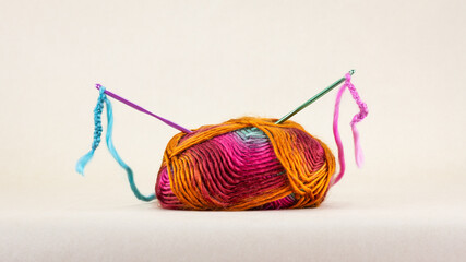 Colourful single ball of wool with crochet hooks and thread,
