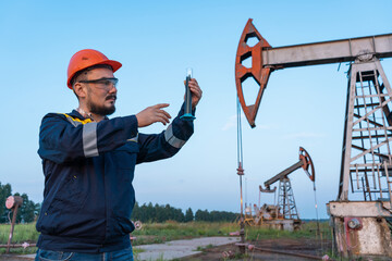 Oil refining. A man takes a sample of oil at an oil field