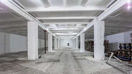 Industrial building interior with white brick walls, concrete floor and empty space for product display or industrial background