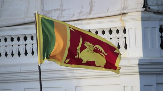 Sri Lankan National Flag waving infront of the Rampart Hotel and Restaurant in Galle Fort Sunset lighting in background, Slow Motion static b roll clip