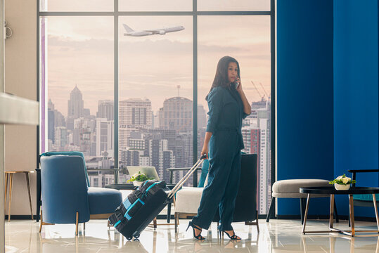 Asian woman preparing for travel on summer vacation. Attractive asian woman with luggage,  talking on smartphone ready for traveling at luxury modern apartment, Condo, Home or Hotel. Vintage Tone   