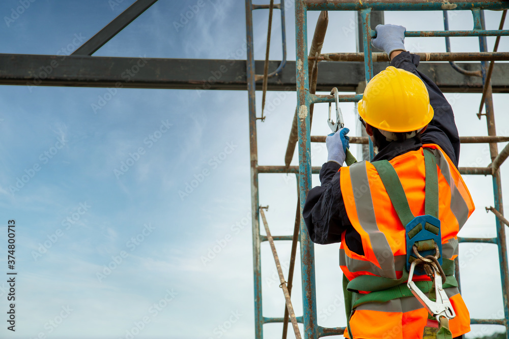 Wall mural Asian worker wear safety height equipment. Fall arrestor device for worker with hooks for safety body harness, Worker as in the construction site