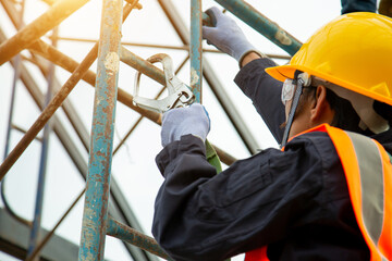 Asian worker wear safety height equipment. Fall arrestor device for worker with hooks for safety...