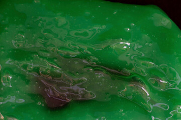 The texture of green slime on a black background. Design for halloween. The photo