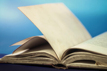 Old vintage opened book with a light blue background
