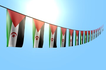 cute any occasion flag 3d illustration. - many Western Sahara flags or banners hanging diagonal on string on blue sky background with soft focus