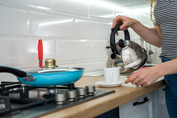 Portrait of young woman enjoy coffee or tea in kitchen