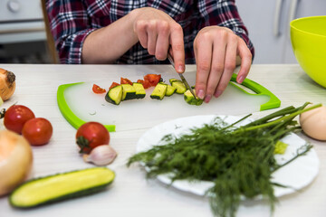 cute girl prepares a salad of different vegetables and greens for a healthy lifestyle.