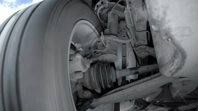 The front car wheel is driving on the road, turns to the right, to the left. The suspension elements are visible: CV joint, shock absorber, brake hoses, hub, stabilizer bar and more