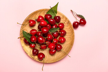 Plate with sweet cherry on color background