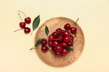 Plate with sweet cherry on color background