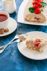 Delicious meringue roll with strawberry on plate