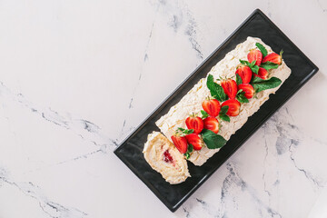 Delicious meringue roll with strawberry on white background