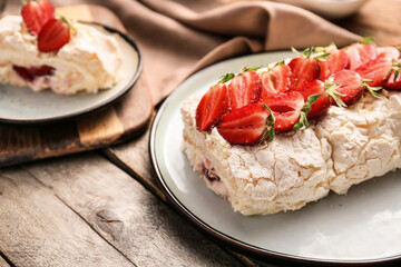 Delicious meringue roll with strawberry on plate