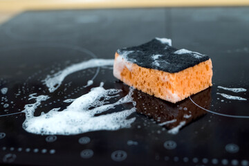  Cleaning kitchen stove.  modern gas stove with a sponge and foam