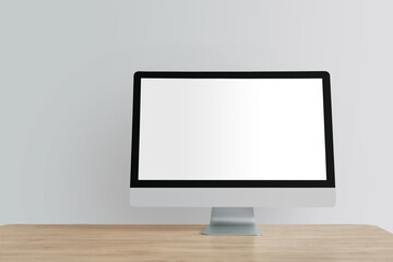 Modern PC monitor on table near light wall