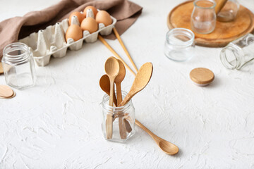 Jar with wooden cutlery on white background. Ecology concept