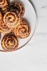 cottage cheese bun on marble background with copy space. Traditional finnish cinnamon rolls on the plate