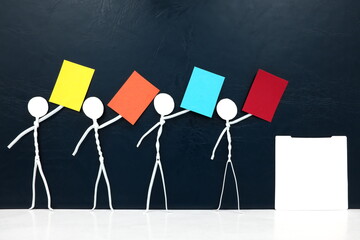 Stick man figure holding multicolored paper near a vote ballot box. Political colors at election...