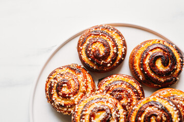 cottage cheese bun on marble background with copy space. Traditional finnish cinnamon rolls on the plate