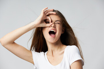 Cheerful woman with open mouth holds hand near face emotions white t-shirt 