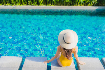 Obraz premium Portrait beautiful young asian woman relax happy smile around outdoor swimming pool in hotel resort