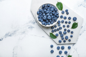 Tasty blueberry in bowl on light background