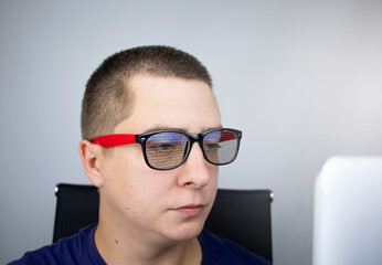 The programmer's glasses reflect lines of code. Programming, development of applications, sites and other things. Software development concept