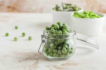 Frozen peas in a glass jar. Freezing is a safe method of increasing the shelf life of nutritious foods. Copy space