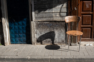 shadow of a chair on a wall and sidewalk in the city