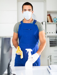 Fototapeta na wymiar Portrait of professional cleaner wearing protective face mask and rubber gloves ready for cleaning in office