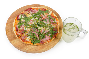 Pizza with ham on pizza board and cup of broth