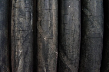 Cracked worn rubber hoses in a coil. Close-up.