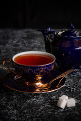 Obraz na płótnie Canvas Vintage tea cup with teapot on a dark background