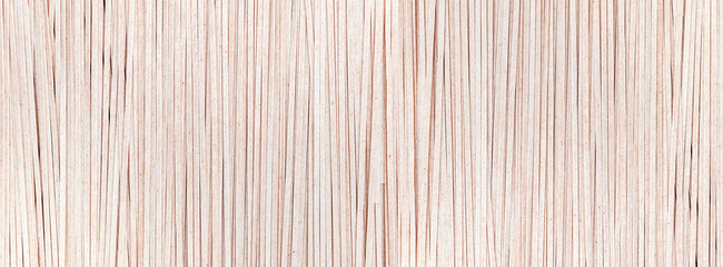 Background of brown soba noodles close up. Asian cuisine, buckwheat pasta, raw, uncooked, dried, natural, organic, vegetarian healthy food. Striped surface. Banner with copy space.