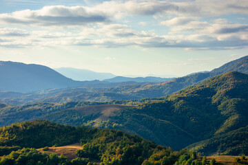 mountainous countryside in the afternoon. beautiful landscape of carpathians. valley of borzhava ridge in the distance. clouds on the sky. sunny weather